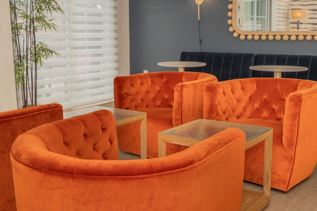 a group of orange chairs and tables in a room at Monmouth Row Apartments, Newport, 41071