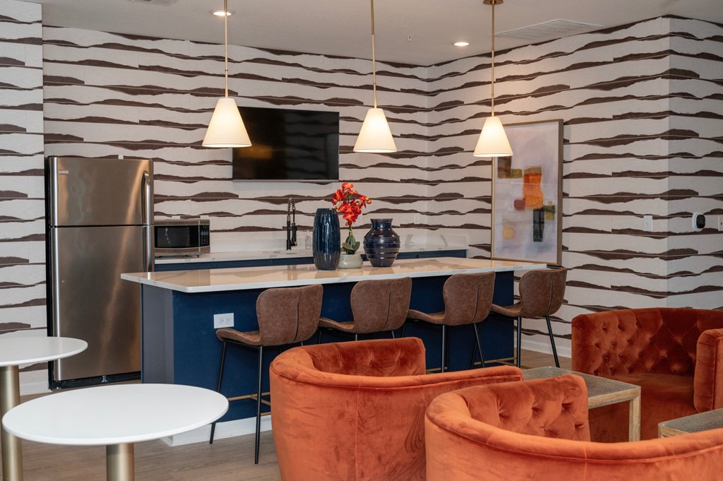a living room with chairs and a table and a kitchen at Monmouth Row Apartments, Newport, Kentucky