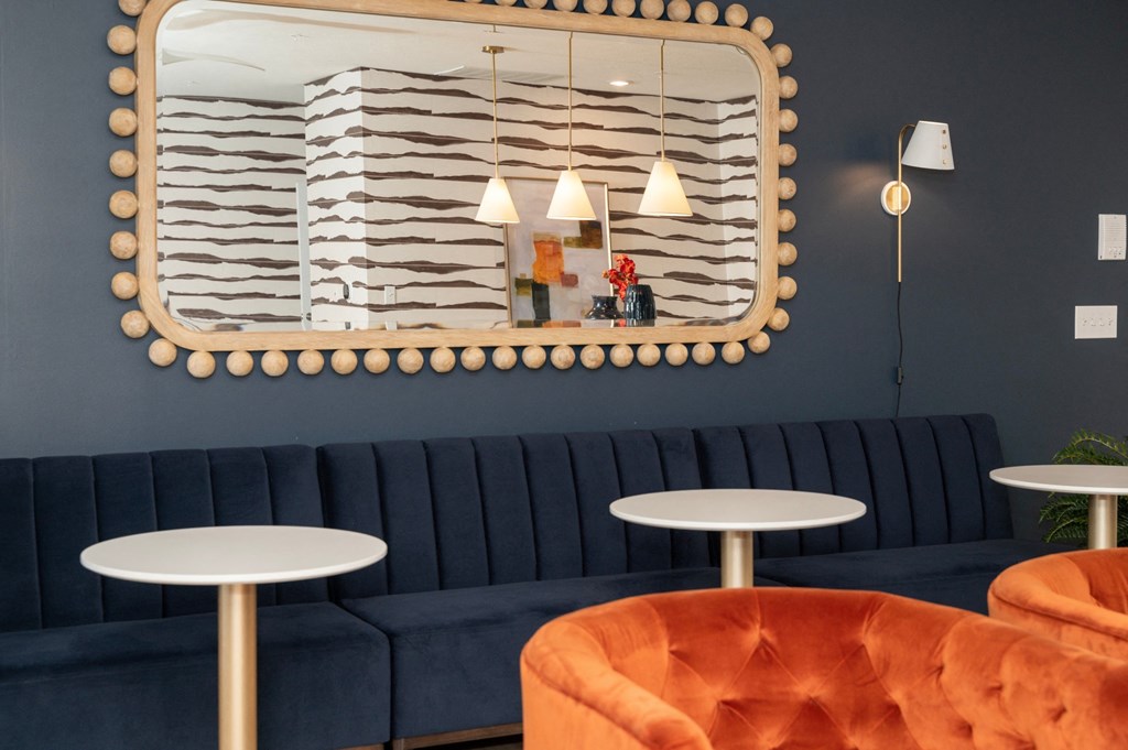 a blue couch and tables in a room with a mirror on the wall at Monmouth Row Apartments, Newport, KY
