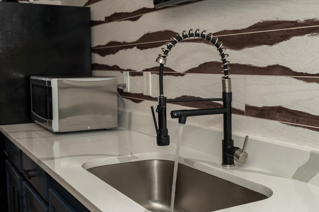 a kitchen sink with a faucet and a microwave on the counter at Monmouth Row Apartments, Newport, 41071