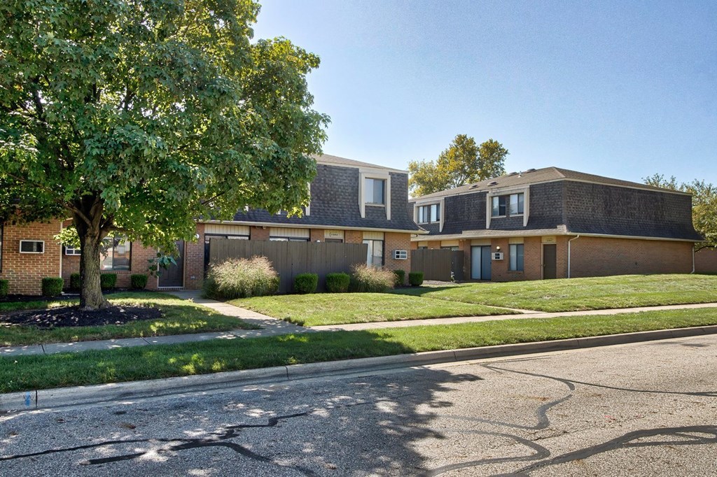 Apartment complex with a tree in front of it.
