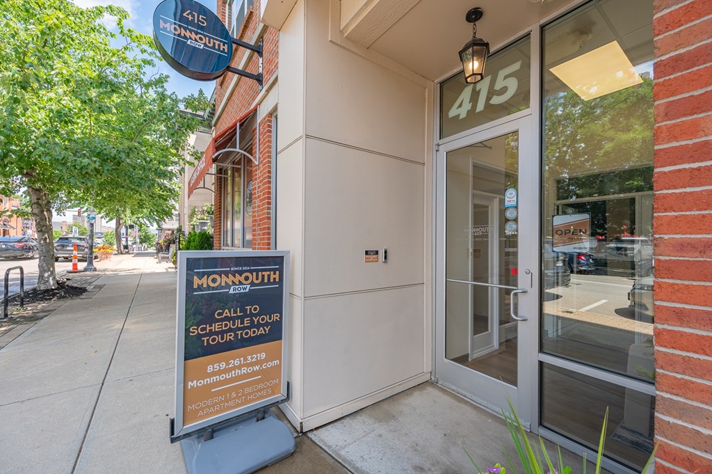 A Monmouth sign is on the sidewalk in front of a building.