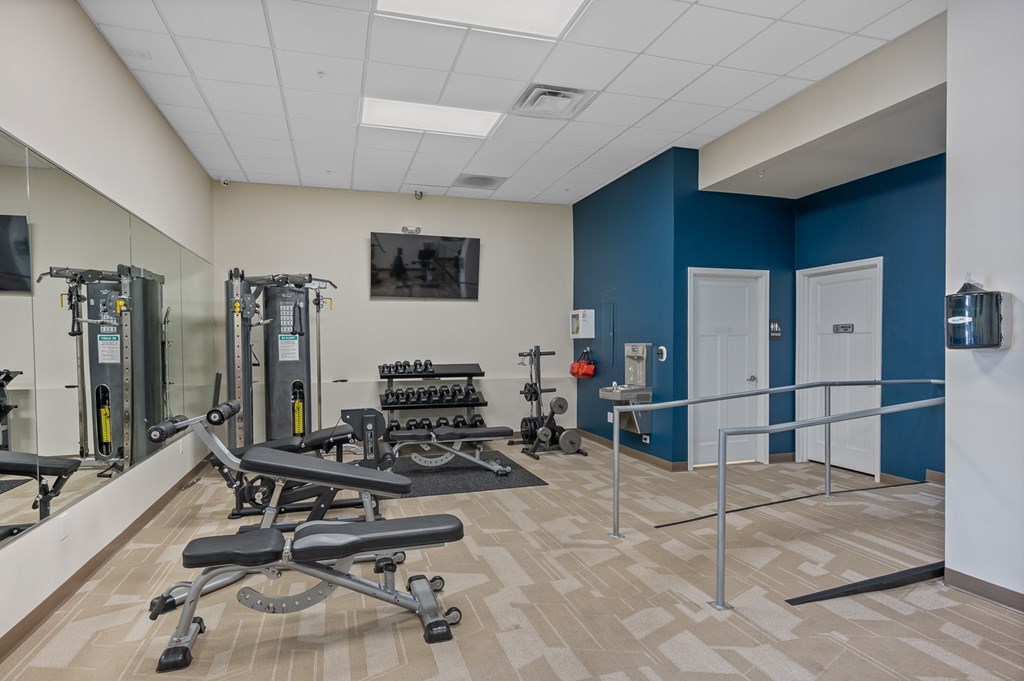 A gym with a blue wall and a mirror.