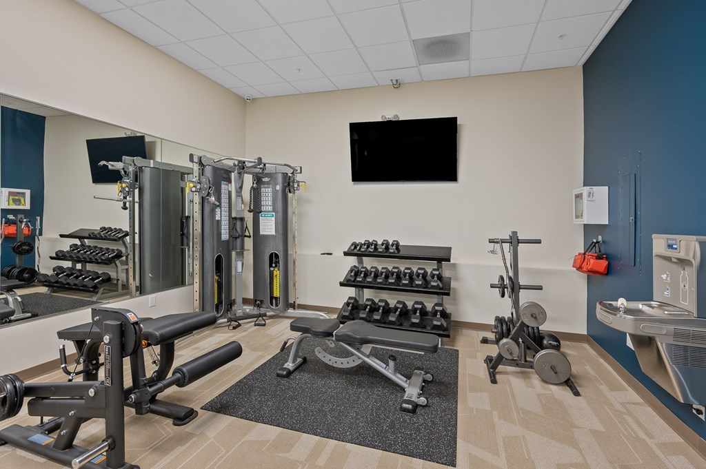 A gym with a variety of equipment including weights and machines.