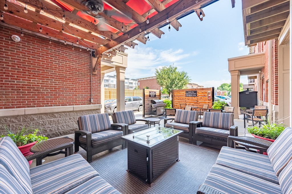 A patio with striped couches and a glass table.