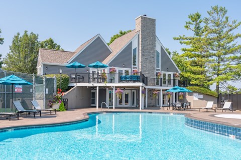 A large house with a pool in front.