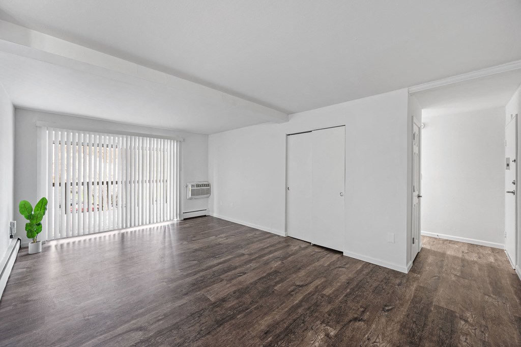 a bedroom with hardwood floors and white walls