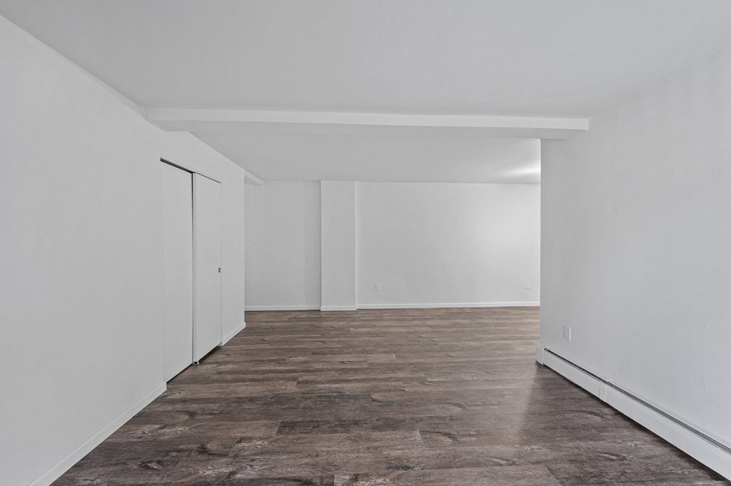 a bedroom with white walls and a wooden floor