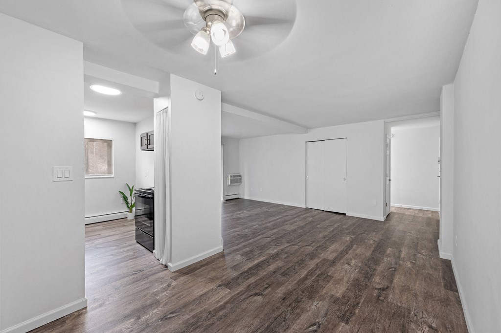 a living room with white walls and a ceiling fan