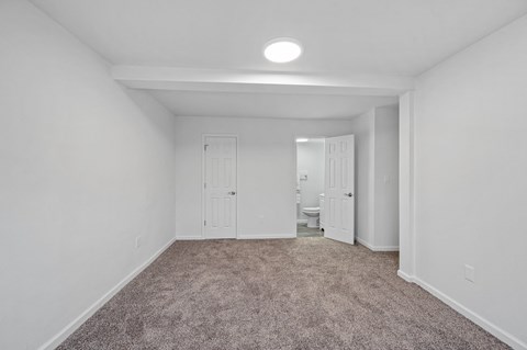 a bedroom with a carpeted floor and white walls