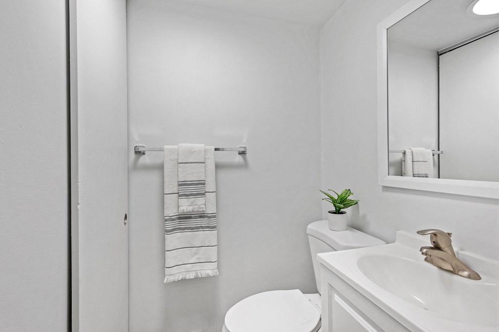 a bathroom with a white sink and toilet next to a shower with a glass door