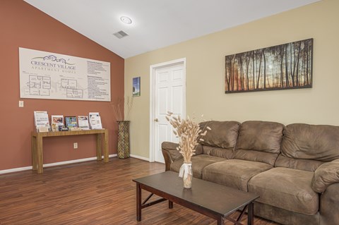 A living room with a brown sofa and a coffee table.