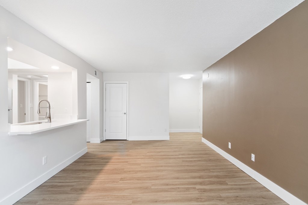 A room with a white sink and brown walls.