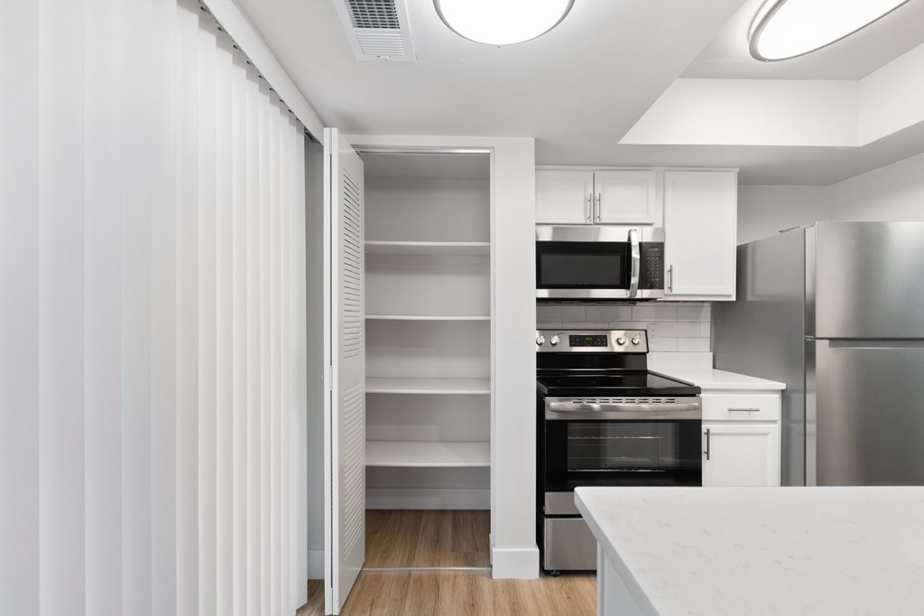 A modern kitchen with a refrigerator, oven, and microwave.