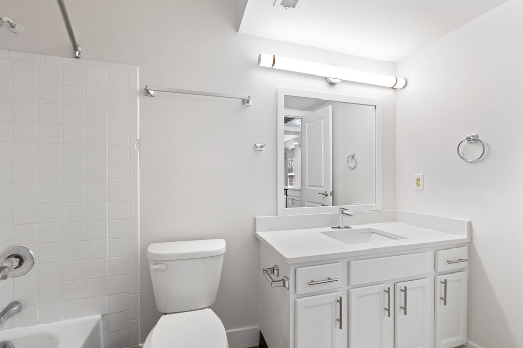 A white bathroom with a toilet, sink, and tub.