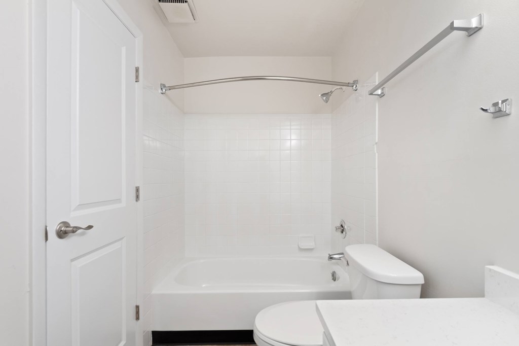 A white bathroom with a toilet, sink, and bathtub.