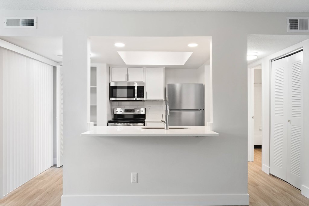 A modern kitchen with white cabinets and appliances.