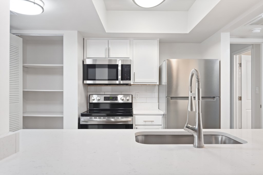 A modern kitchen with stainless steel appliances and white cabinetry.