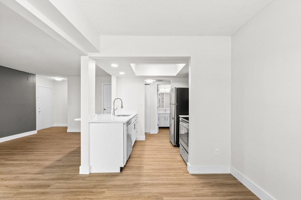 A kitchen with white appliances and a white island.