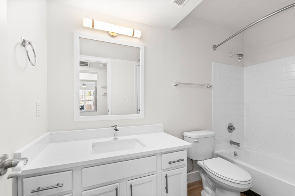 A white bathroom with a sink, toilet, and bathtub.