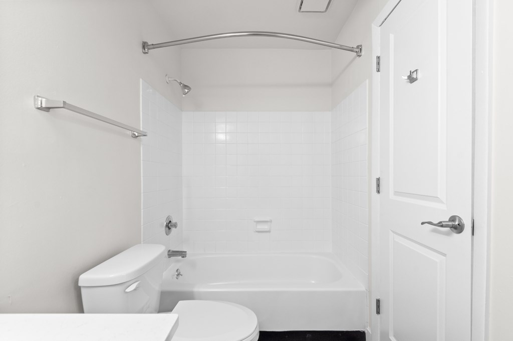 A white bathroom with a toilet, sink, and bathtub.