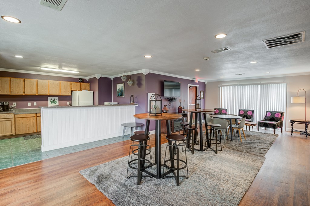 a living room with a dining area and a kitchen with a table and chairs at Crystal Glen Apartments, Findlay