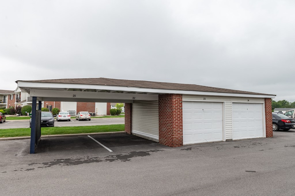 a parking lot with a white garage with a roof at Crystal Glen Apartments, Findlay, Ohio