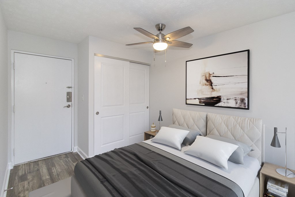 a bedroom with a bed and a ceiling fan
