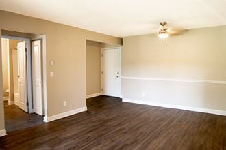 an empty living room with hardwood floors and a ceiling fan - Photo Gallery 5