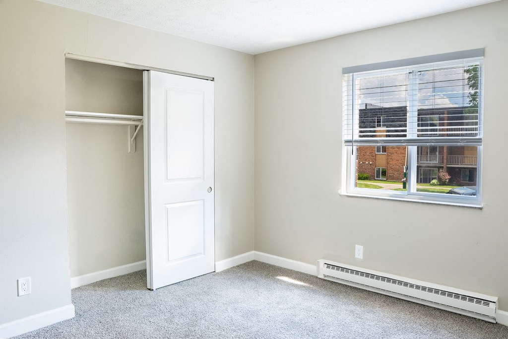 a bedroom with a closet and a large window