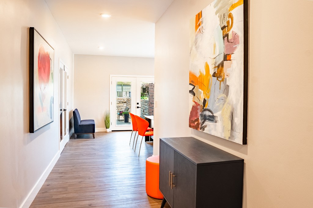 a hallway with white walls and a large painting on the wall