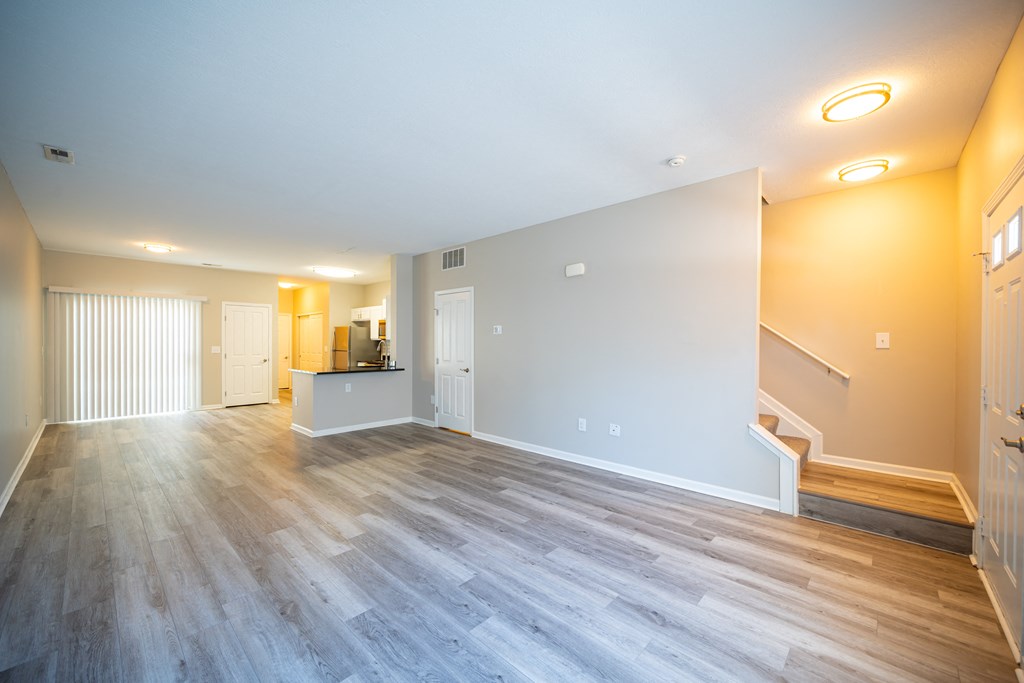 a living room with a hard wood floor and a staircase at Traditions at Slate Ridge, Reynoldsburg, OH