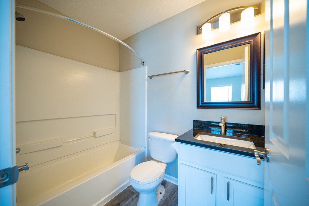 a bathroom with a toilet sink and tub and a mirror at Traditions at Slate Ridge, Reynoldsburg