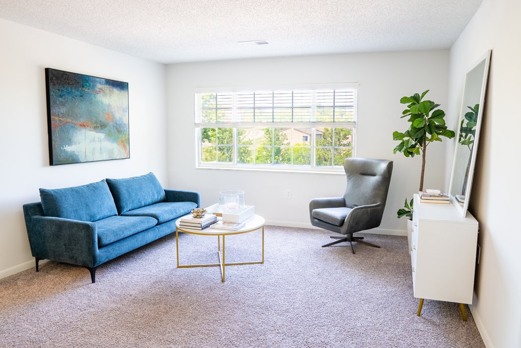 a living room with a blue couch and a blue chair