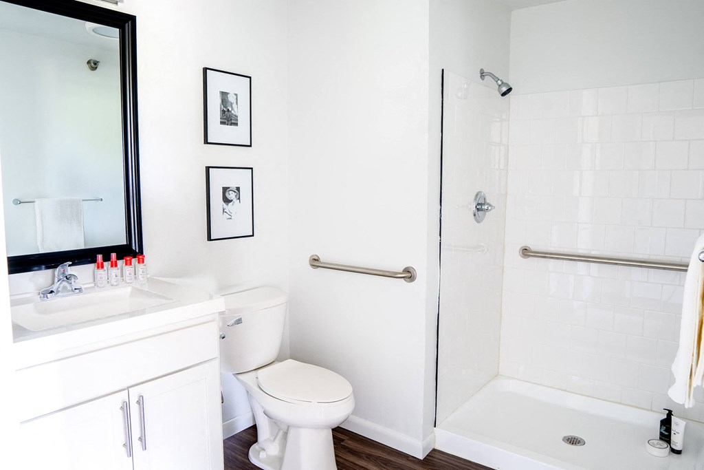 a bathroom with white walls and a white toilet next to a white bathtub