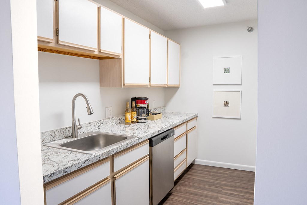 a kitchen with white cabinets and a stainless steel sink