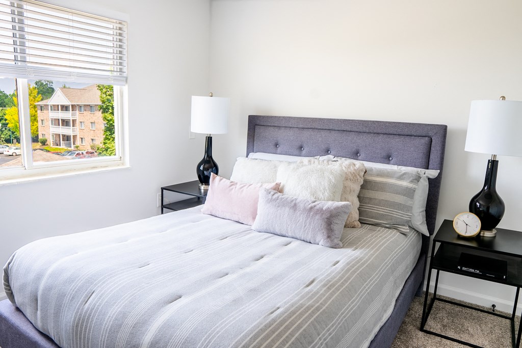 a bedroom with a large bed and two nightstands with lamps on them
