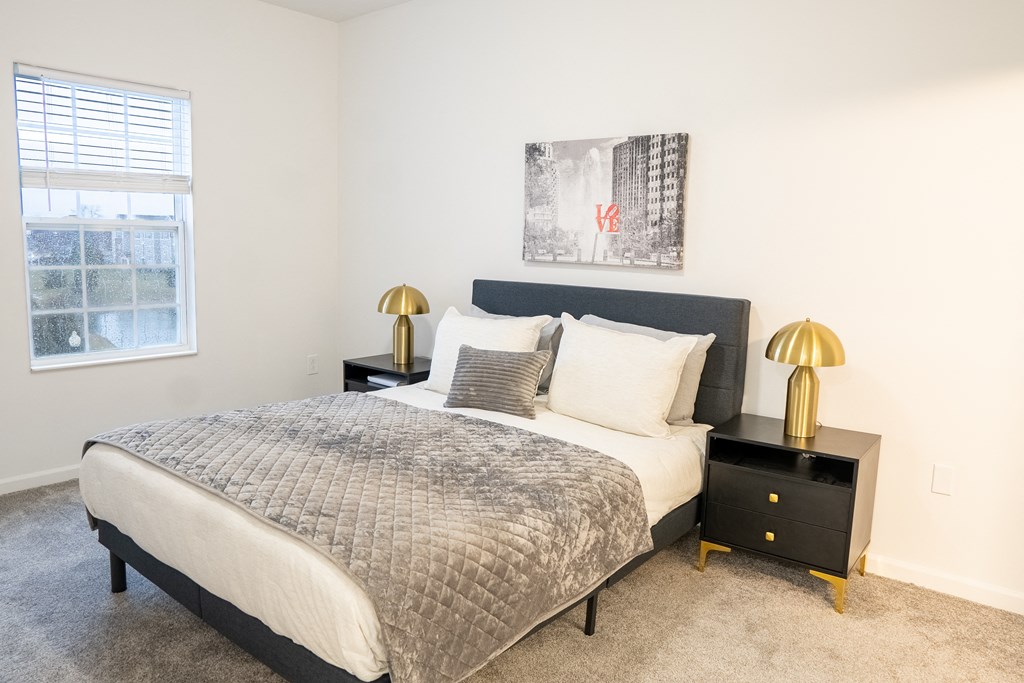 a bedroom with a bed and two nightstands with lamps  at Waterstone Landing, Perrysburg