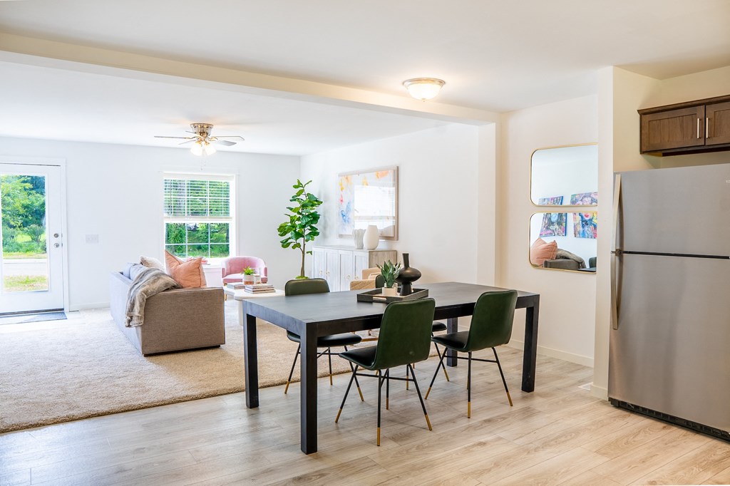 a dining room with a table and chairs and a living room in the background