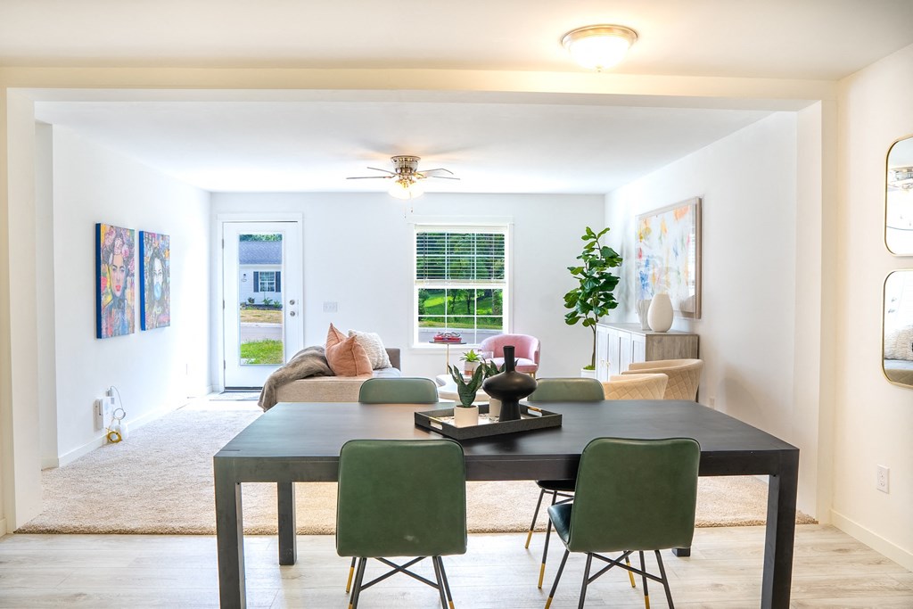 a living room with a large table and green chairs at Hangar Flats, Batavia, 45103