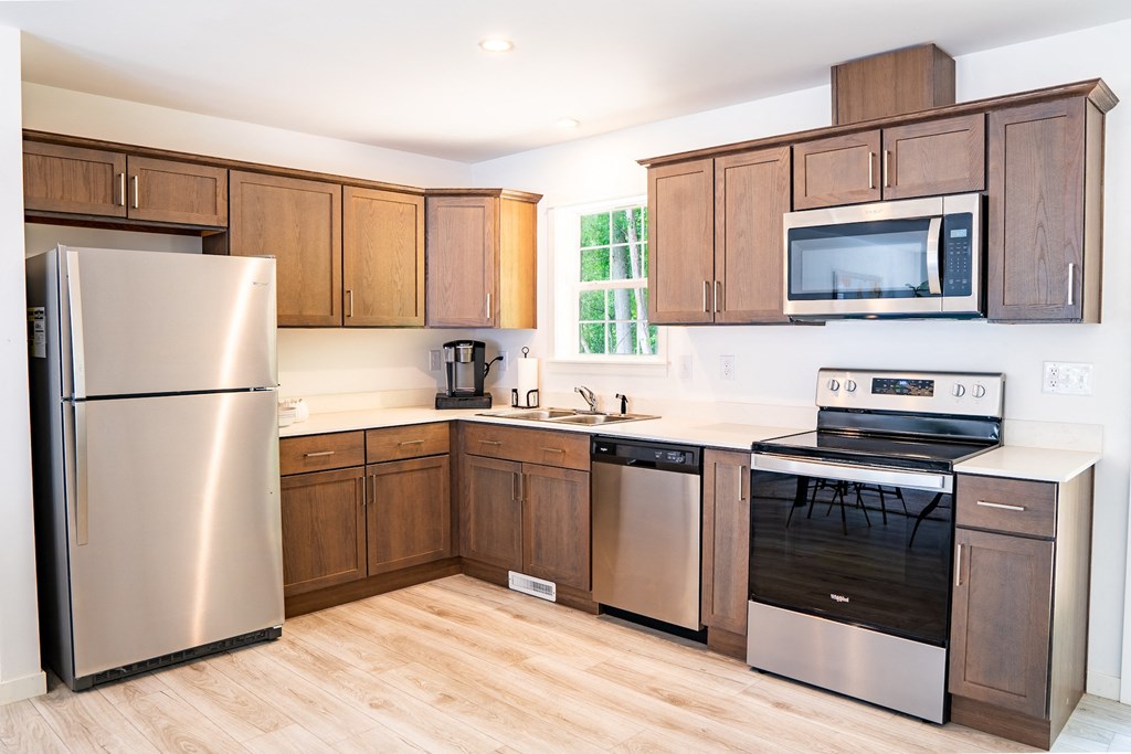 a kitchen with wooden cabinets and stainless steel appliances