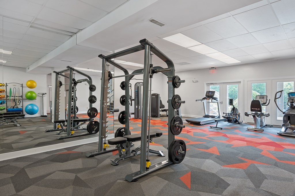 A gym with a variety of equipment including dumbbells and weight machines.
