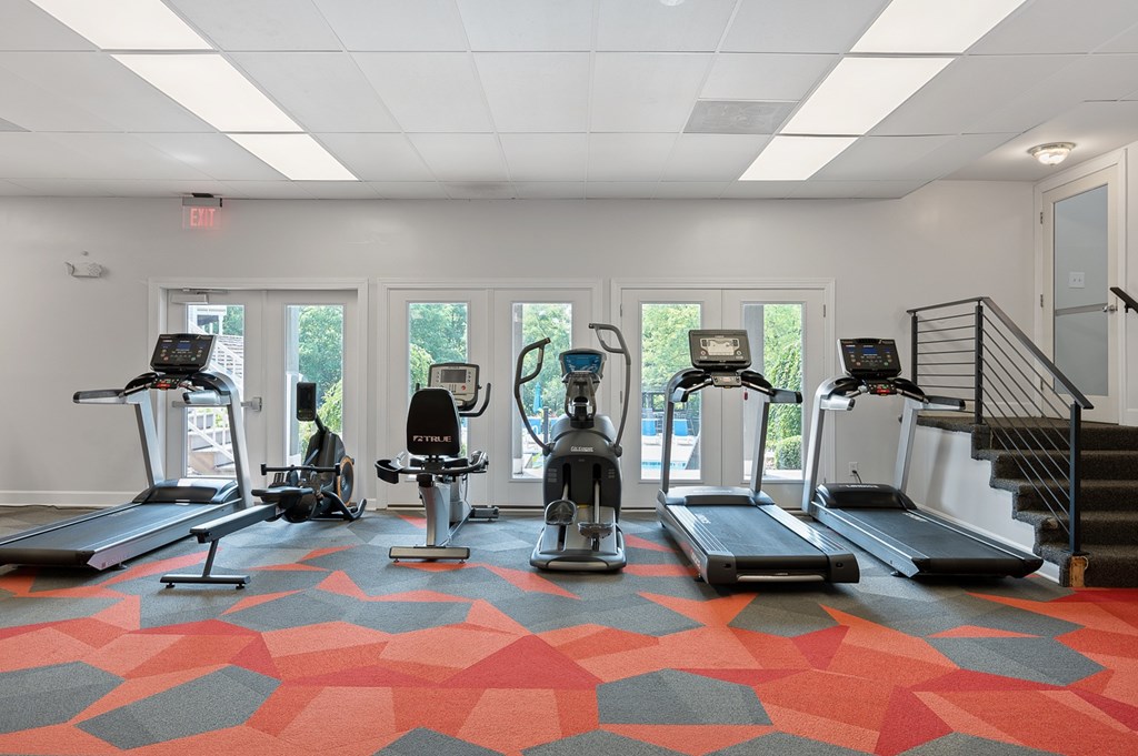 A gym with treadmills, elliptical machines and a stair climber.
