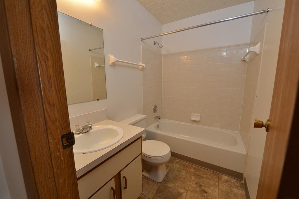 A bathroom with a toilet, sink, and bathtub.