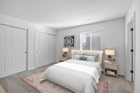 A bedroom with a large bed and two nightstands.