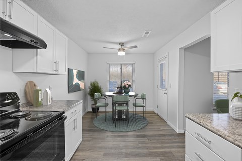 A kitchen with a table and chairs in the middle.
