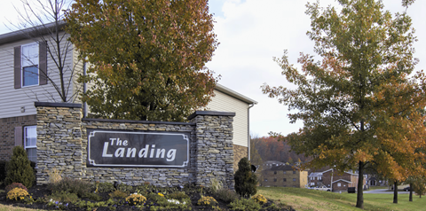A sign that says "The Landing" is on a stone pillar.