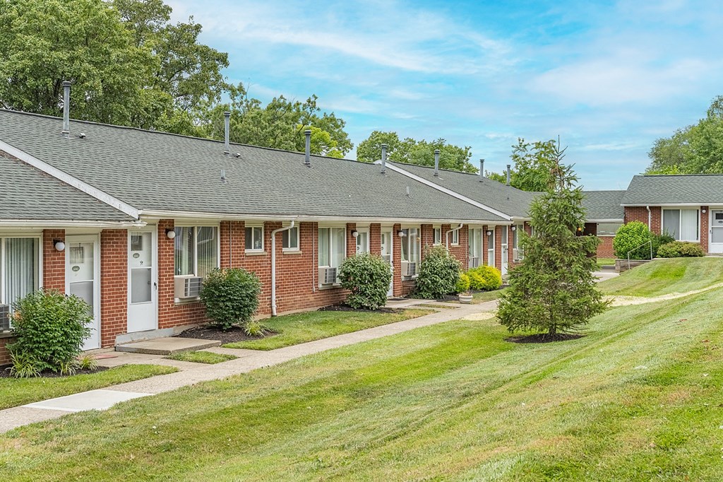 A row of houses with green lawns in front.