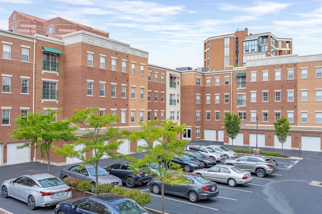 a parking lot filled with cars in front of a brick building