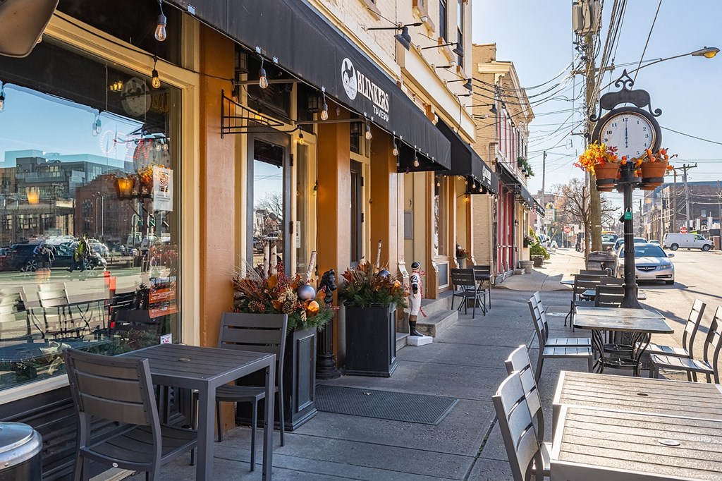 a city street with tables and chairs outside of a restaurant